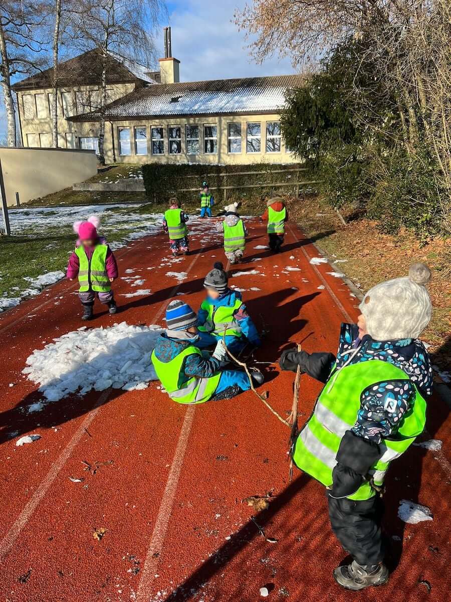 beim schulhaus mit schnee spielen und rennen kinderbetreuung kinderkrippe und waldkinderkrippe blueemli in zuerich witikon